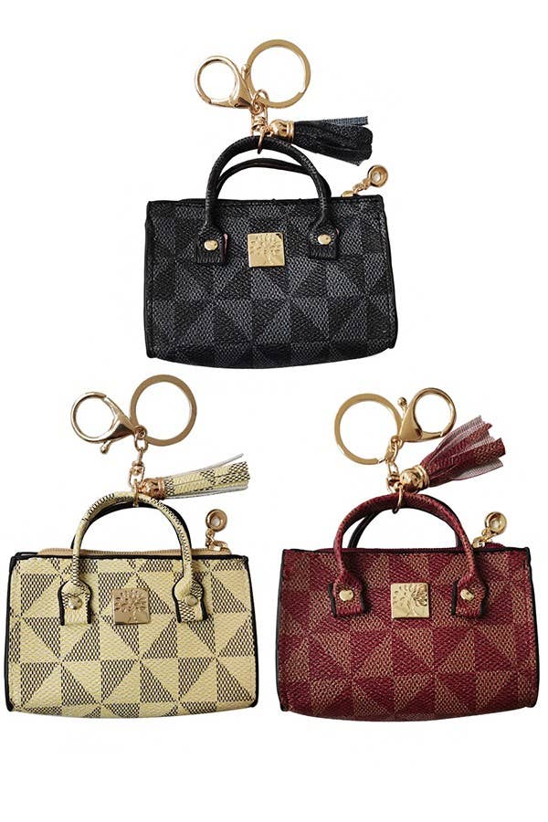 Set of three small handbags with matching keychains on a white background