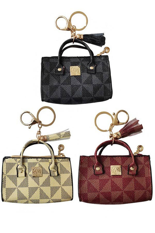 Set of three small handbags with matching keychains on a white background